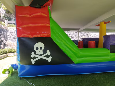Alquiler Barco Pirata inflable CDMX - Detalle calavera y tobogán lateral en evento jardín