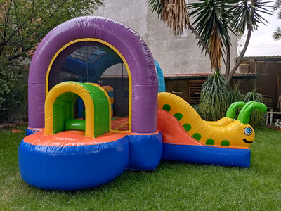 Renta inflable Gusanitos CDMX - Vista frontal brincolin en jardín exterior con gusanitos coloridos